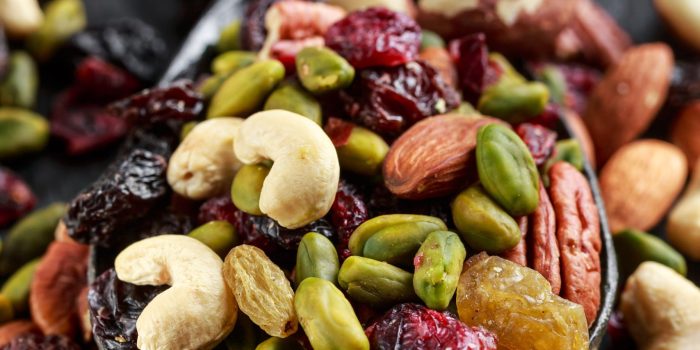 Nuts and dried fruits mix on wooden spoon